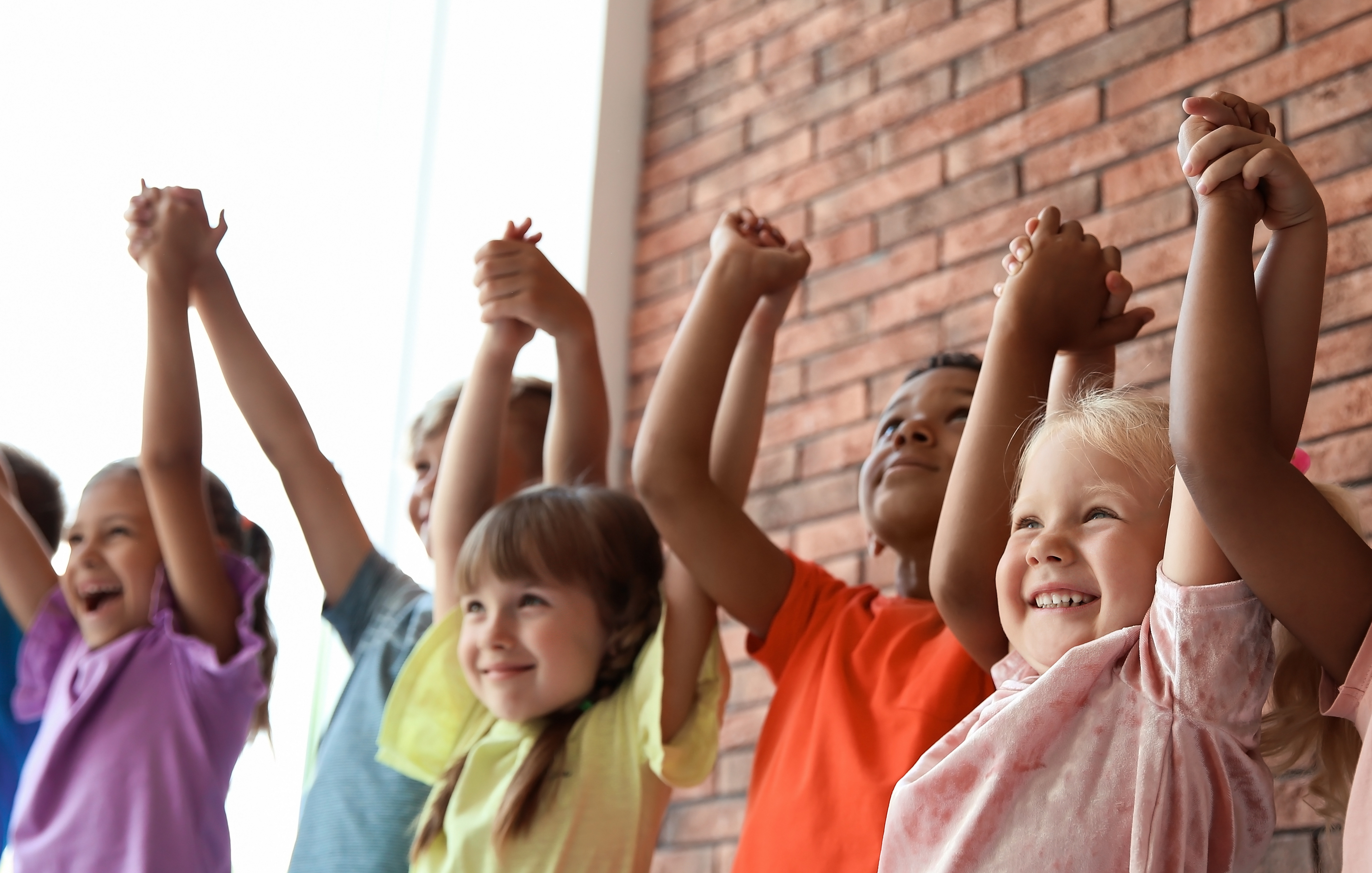 Little children holding hands together indoors. Unity concept