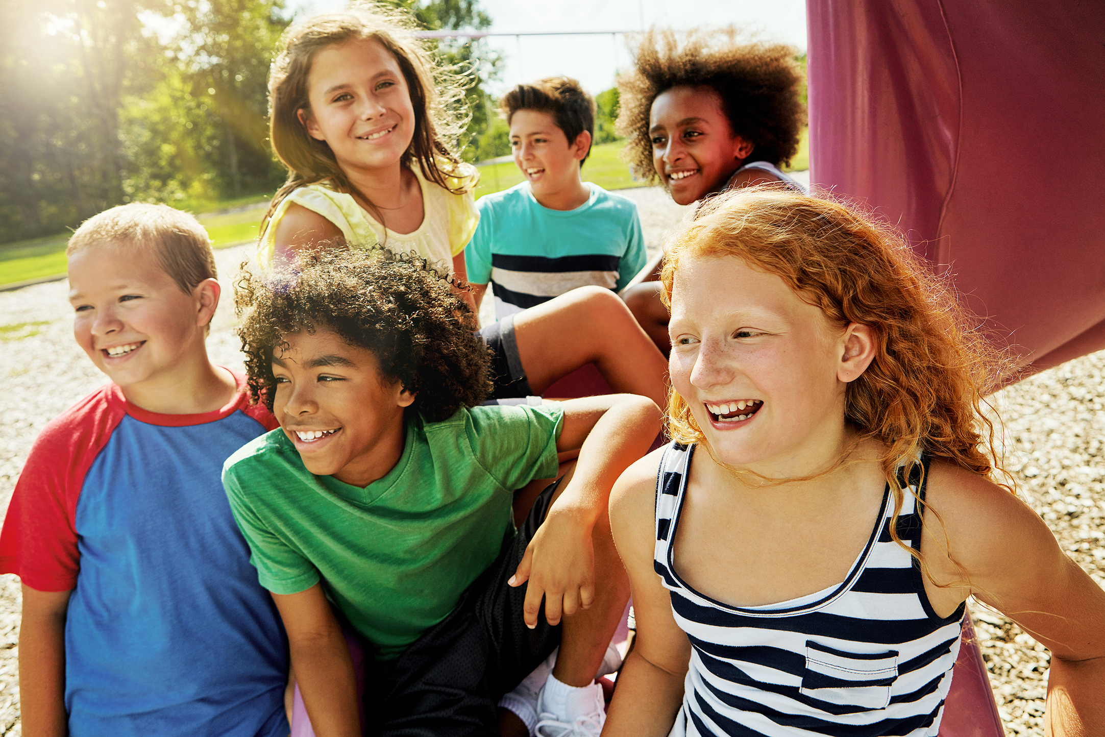 Cropped shot of a group of diverse and happy kids hanging out together outside