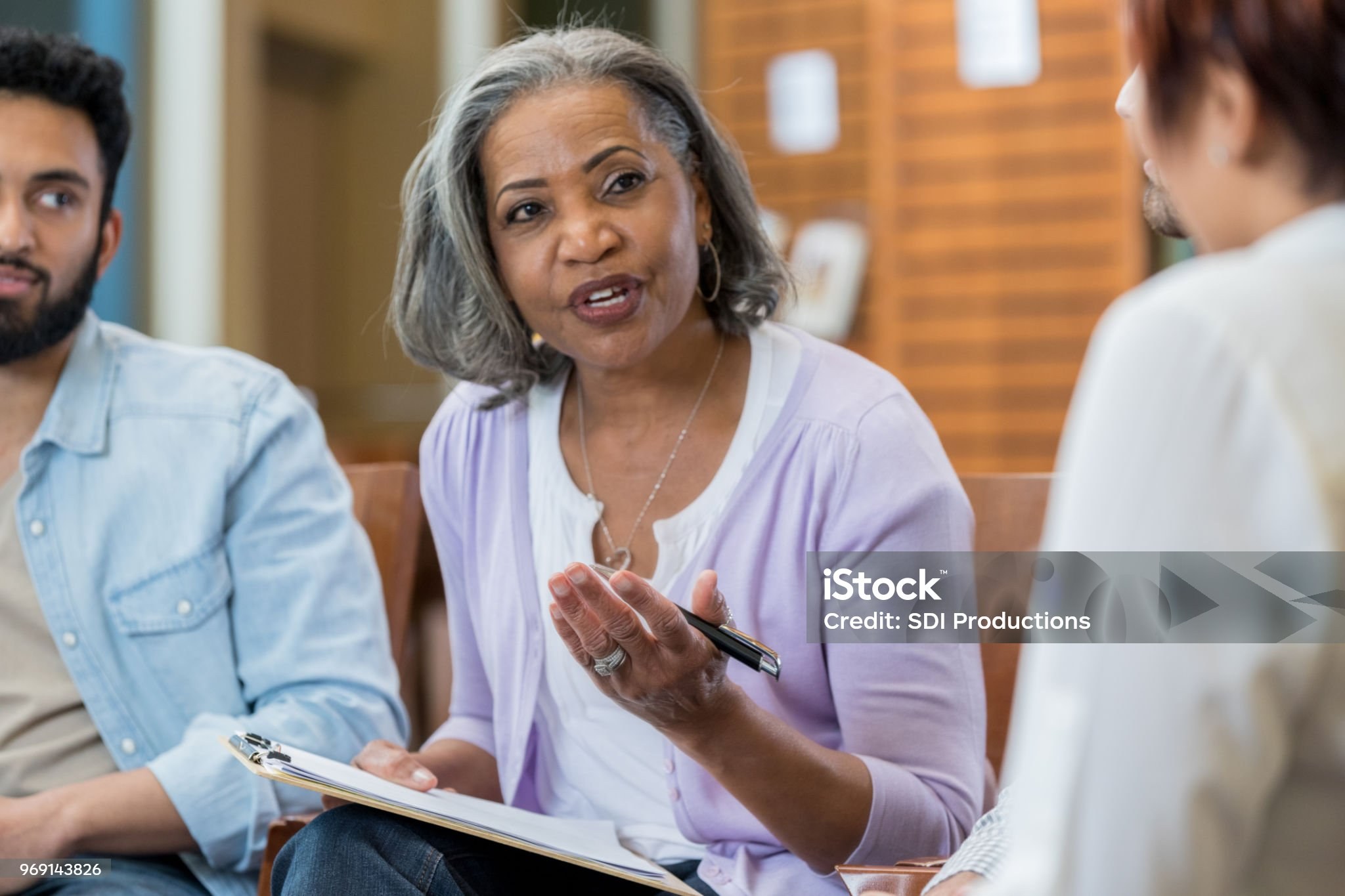 Confident senior African American female therapist discusses something during a support group meeting.
