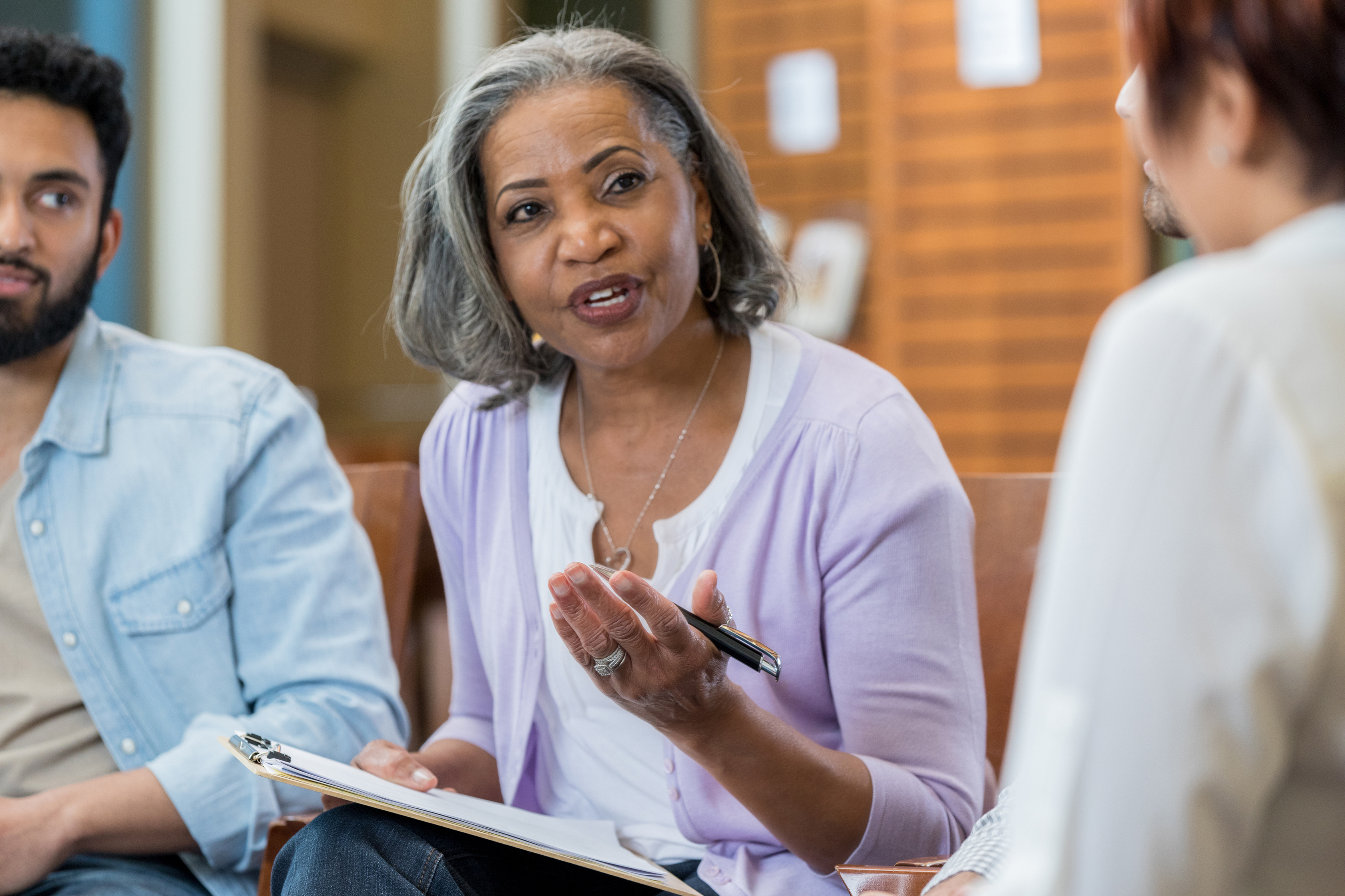 Confident senior African American female therapist discusses something during a support group meeting.