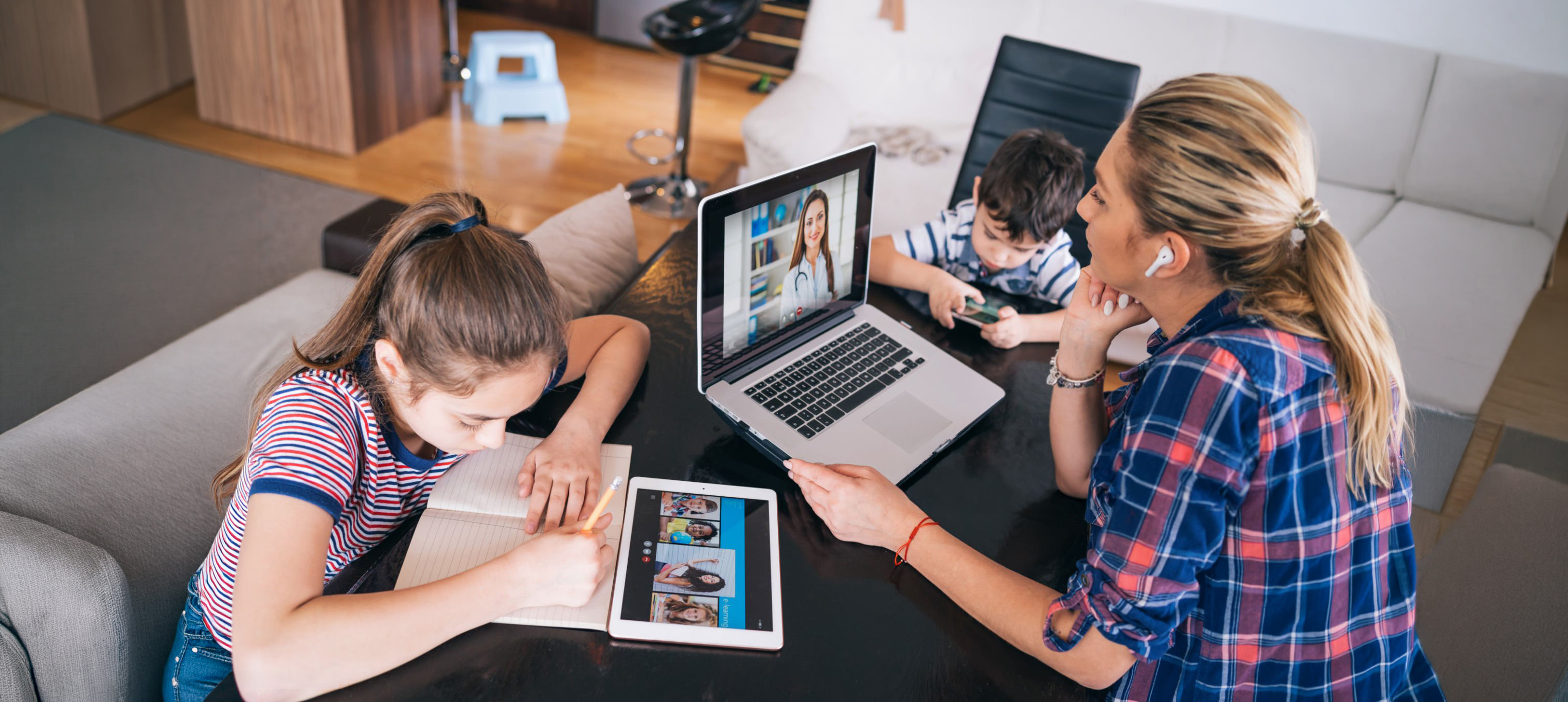Mother trying to talk with doctor on laptop while watching two kids staying home. Homeschooling and distance learning