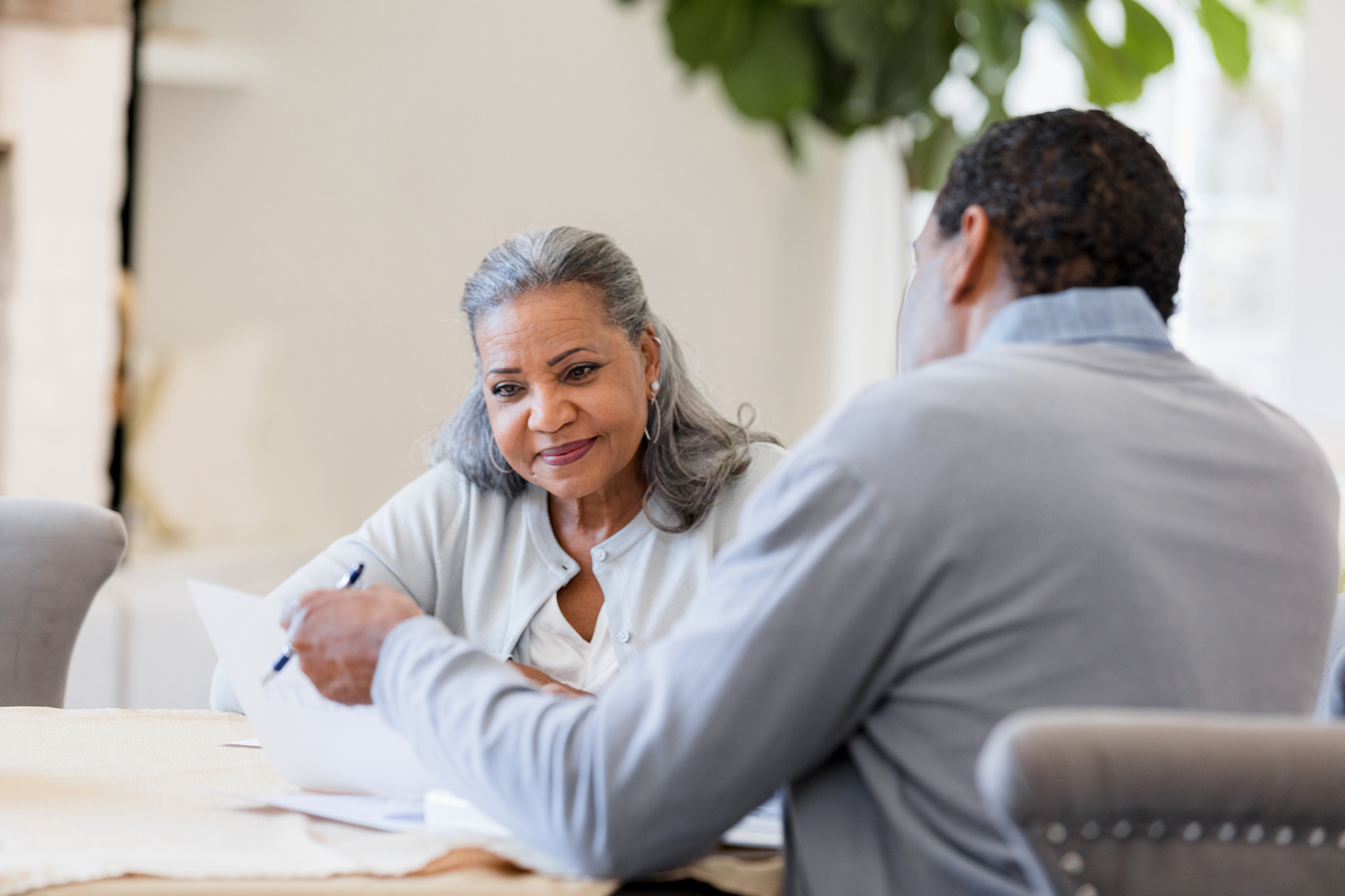 Senior woman and man reviewing documents, planning retirement.