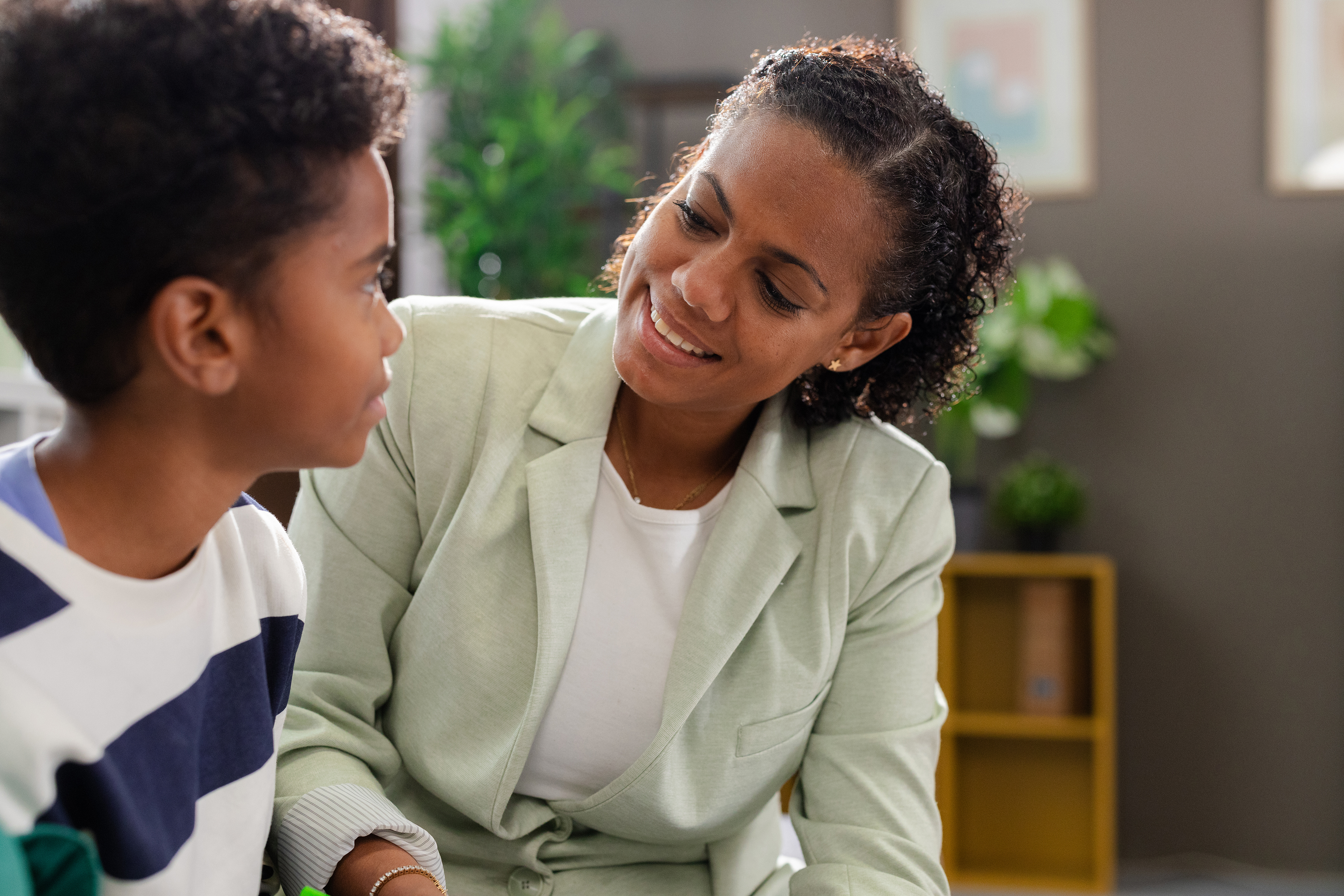 Smiling therapist listening to young patient during therapy session at office