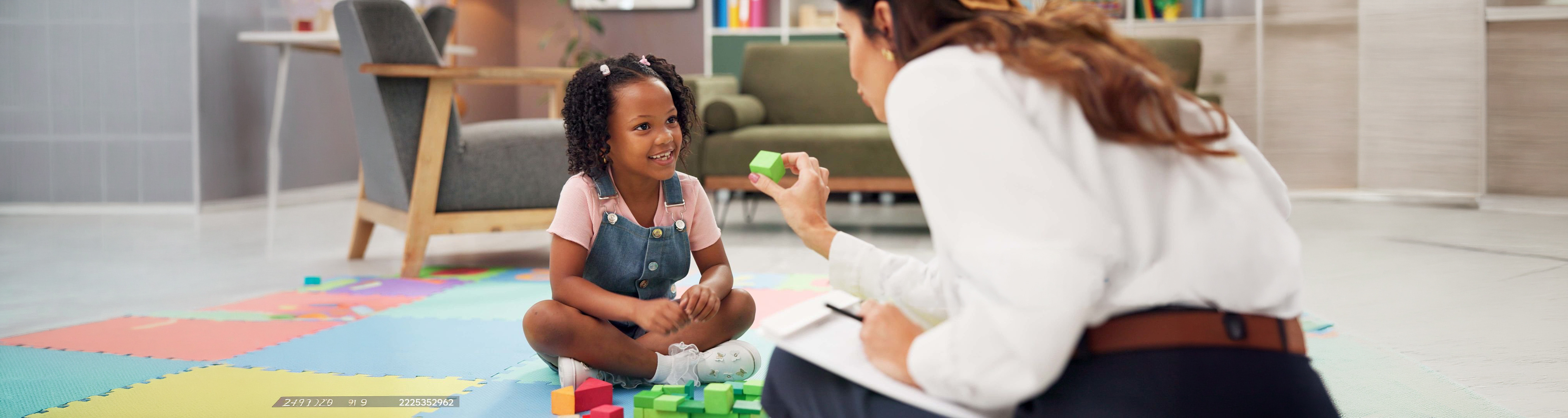 Child, teacher and blocks with toys for learning, education or childhood development at private school. Female person, kid or elementary student with smile for fun activity, shape or growth in class